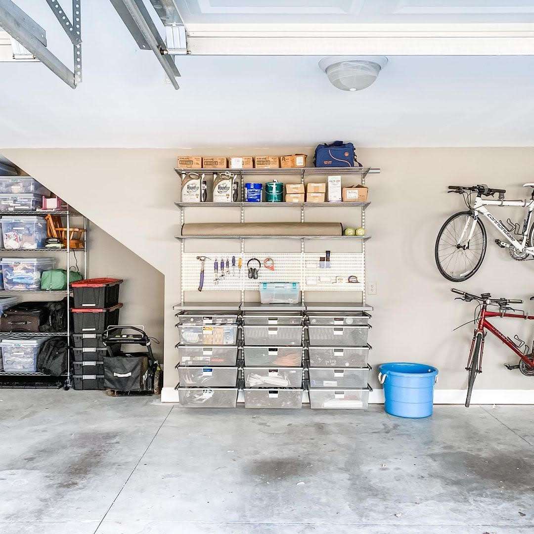 Garage med hyllor, lådförvaringssystem och cyklar på väggen