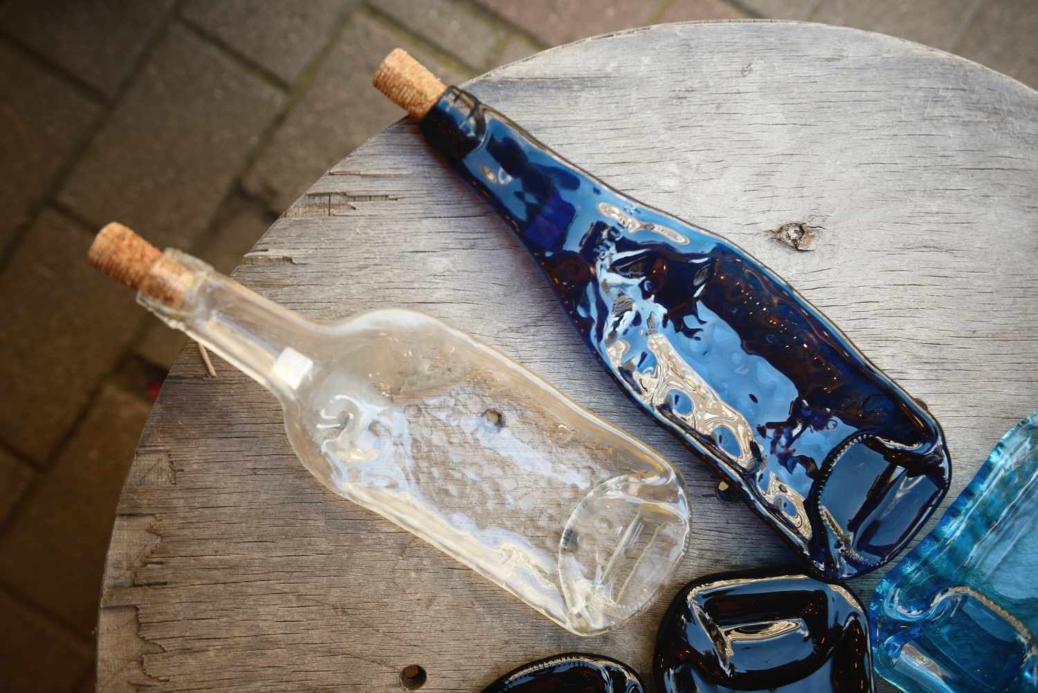 Melted glass bottles on a wood table