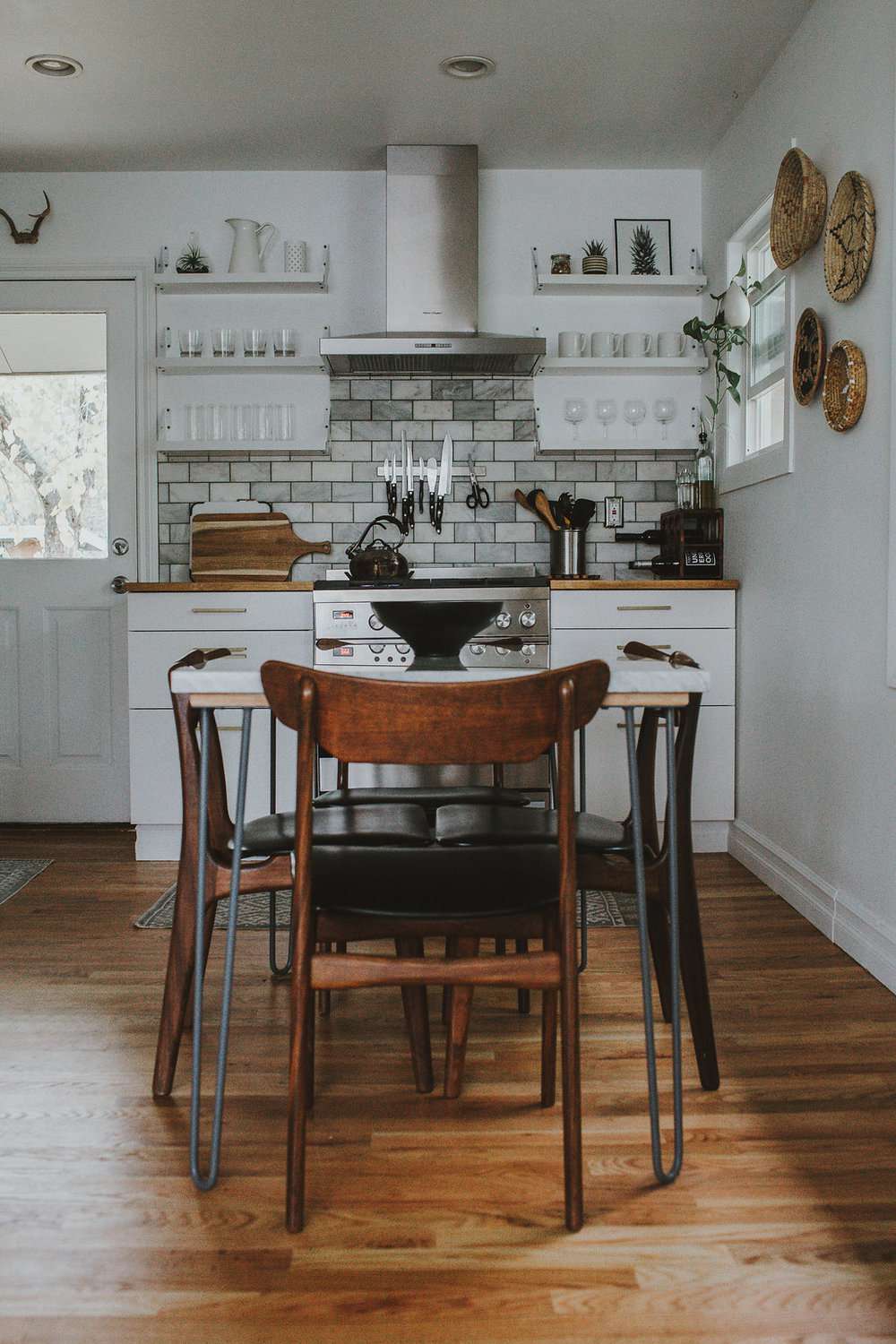 kök med vit kakelbacksplash och rustikt köksbord