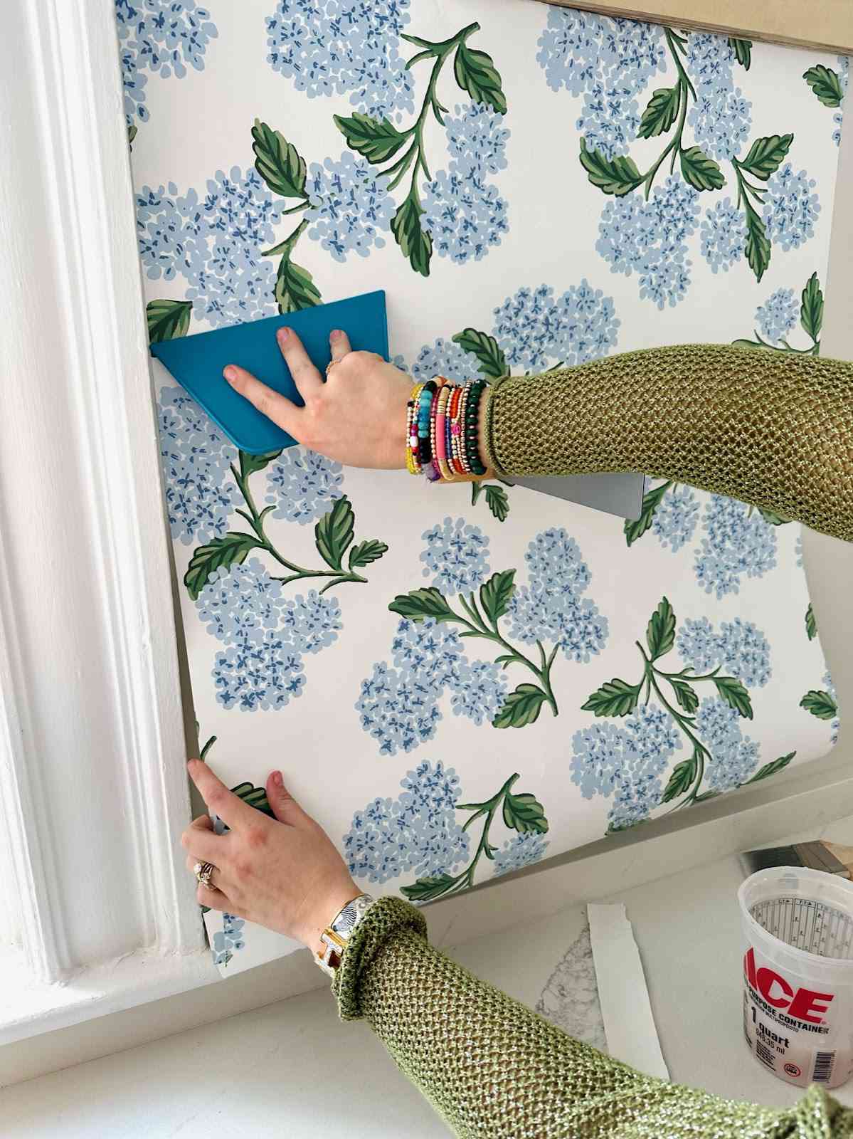 Clare slätar ut tapet på vägg.