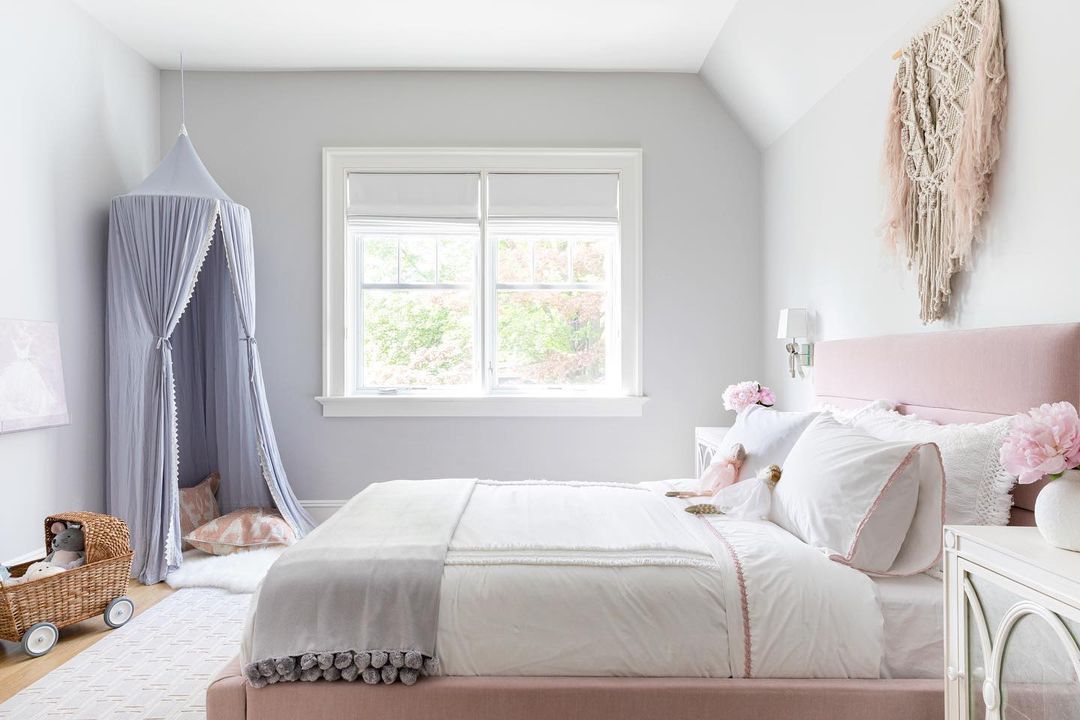 En tweenflickas sovrum med en tia i hörnet, en rosa stoppad säng och en stor makramé hängande ovanför sängen.