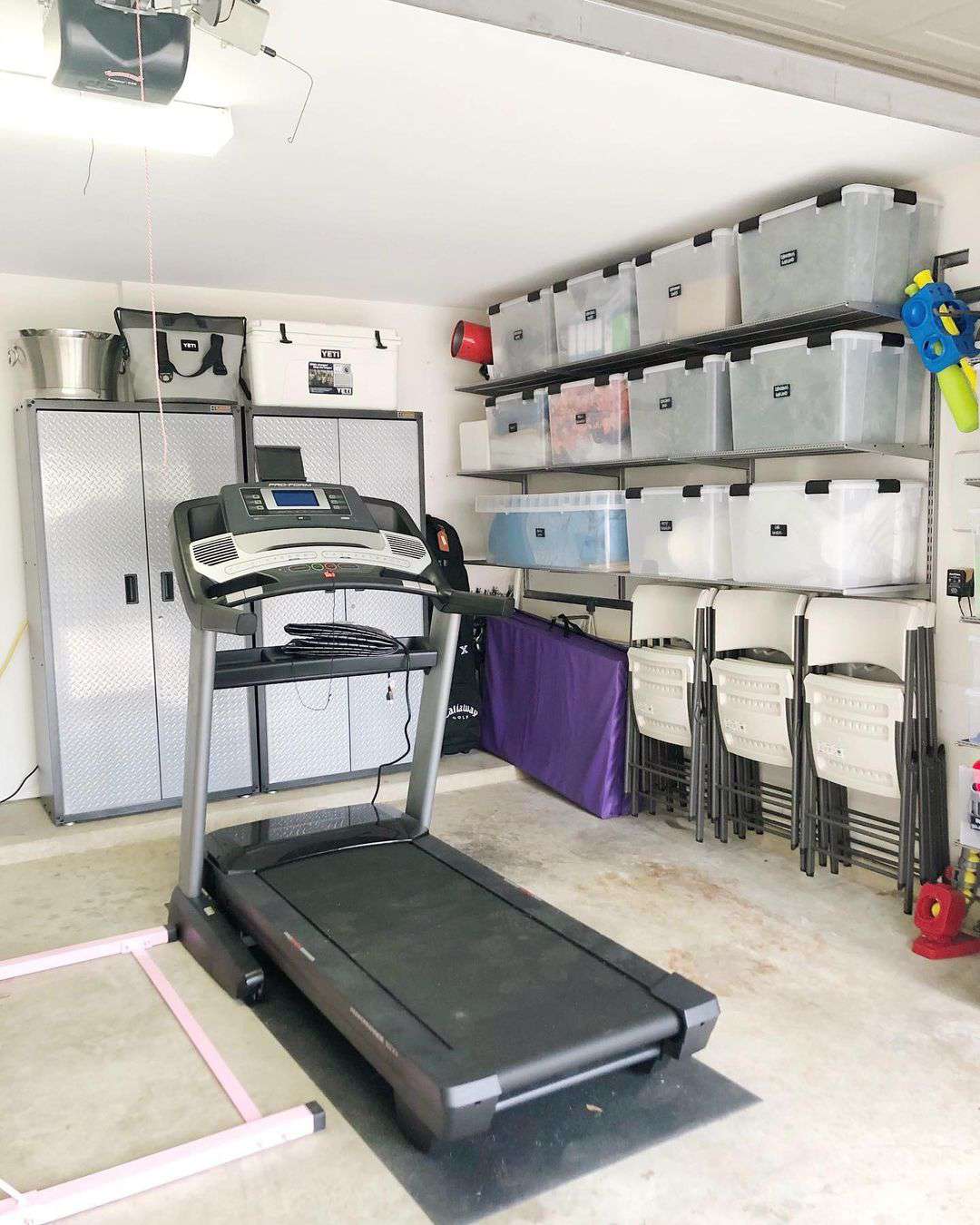 Löpband och organiserade hyllor i ett garage