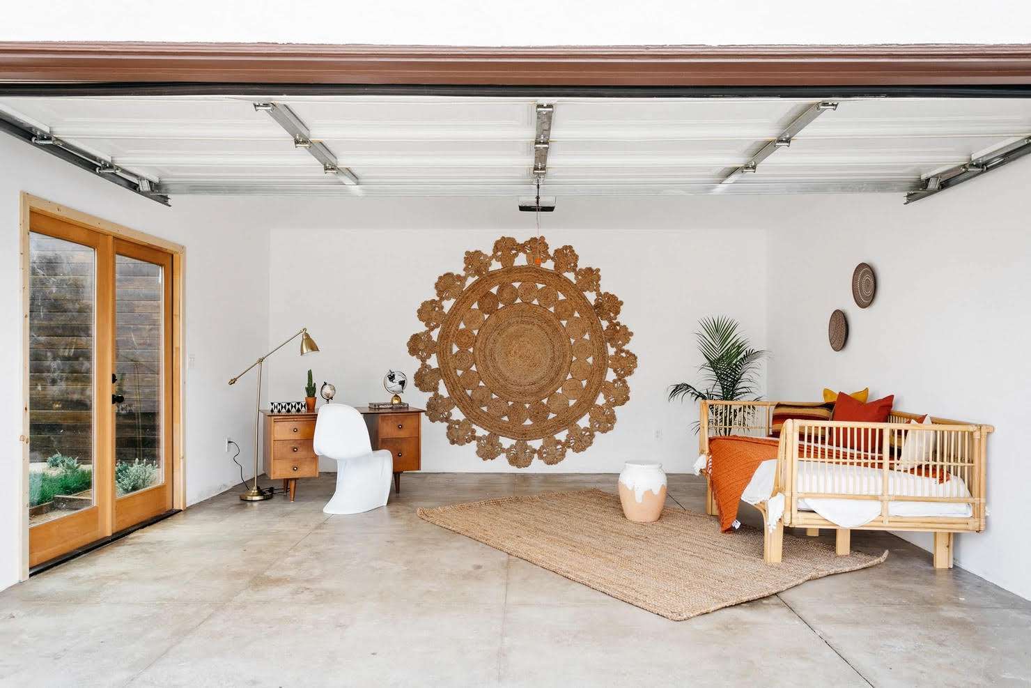 Ombyggt garage som har en rund jute-matta på väggen och en dagbädd och skrivbord inuti