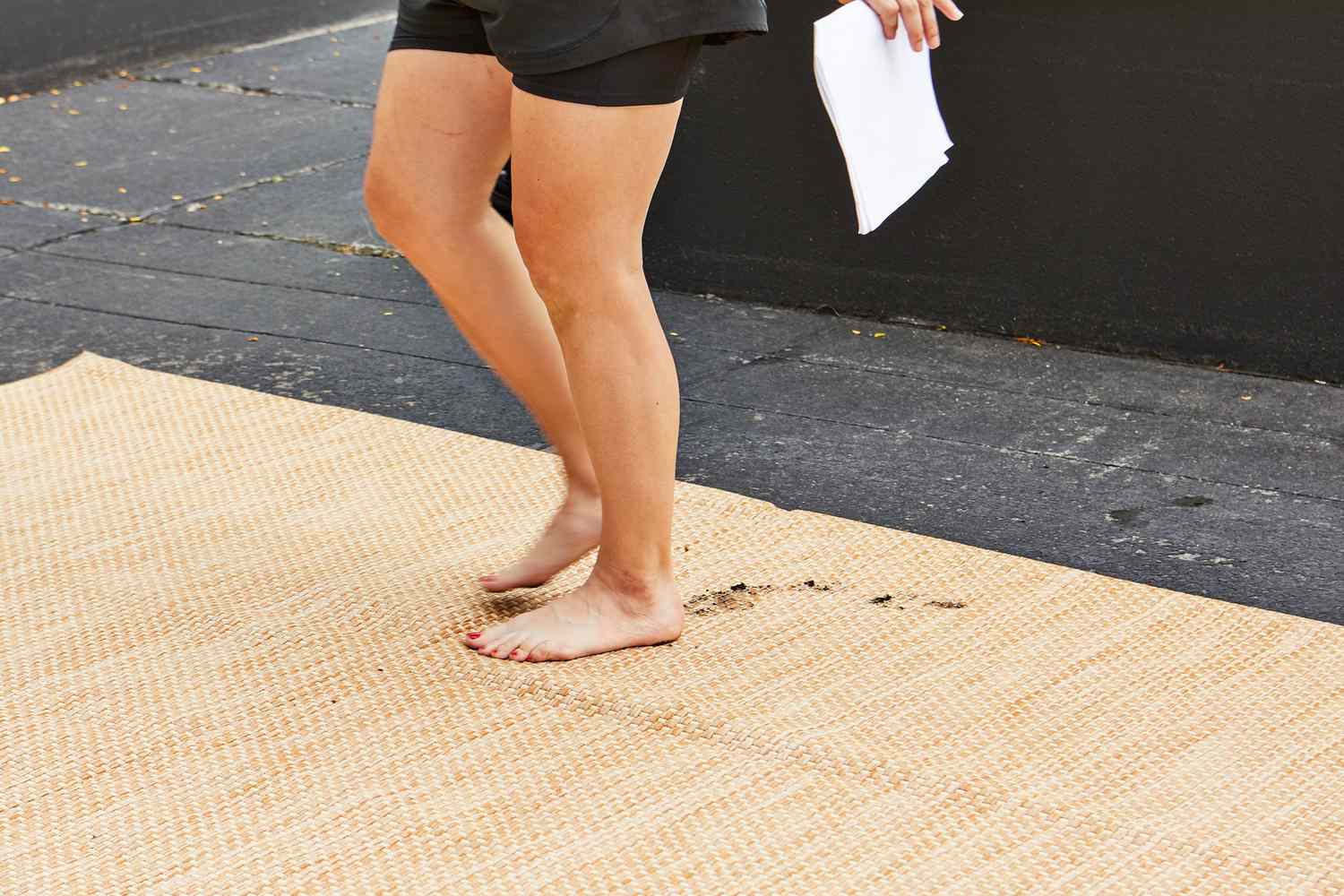 Person med leriga fötter som går på en Safavieh Courtyard Beige and Brown Solid Indoor/Outdoor Area Rug