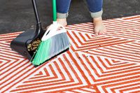 Person skjuter spill på Urban Outfitters Tillie Reversible Indoor/Outdoor Rug i soptunna