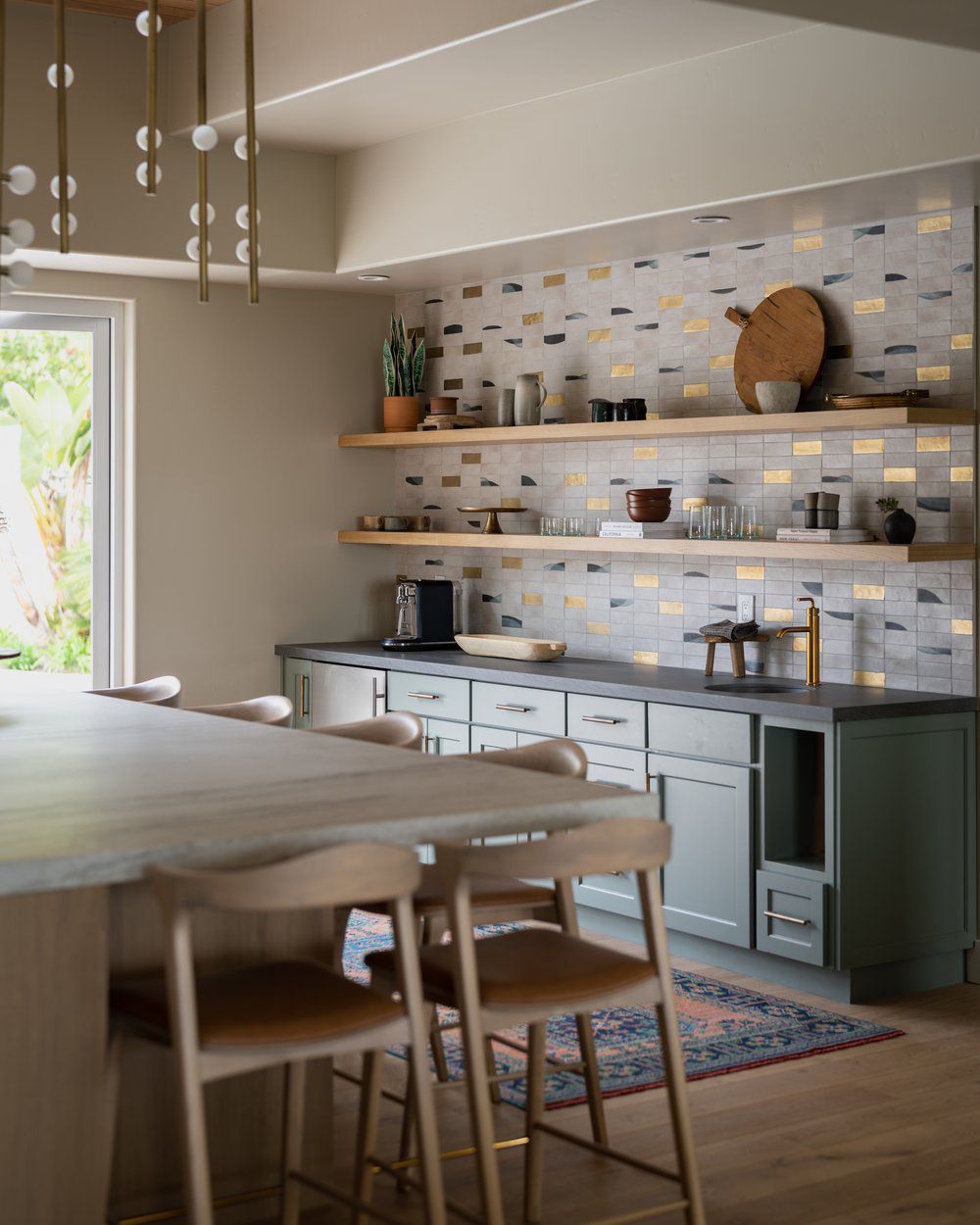 Beige kök med gyllene statementplattor i backsplash