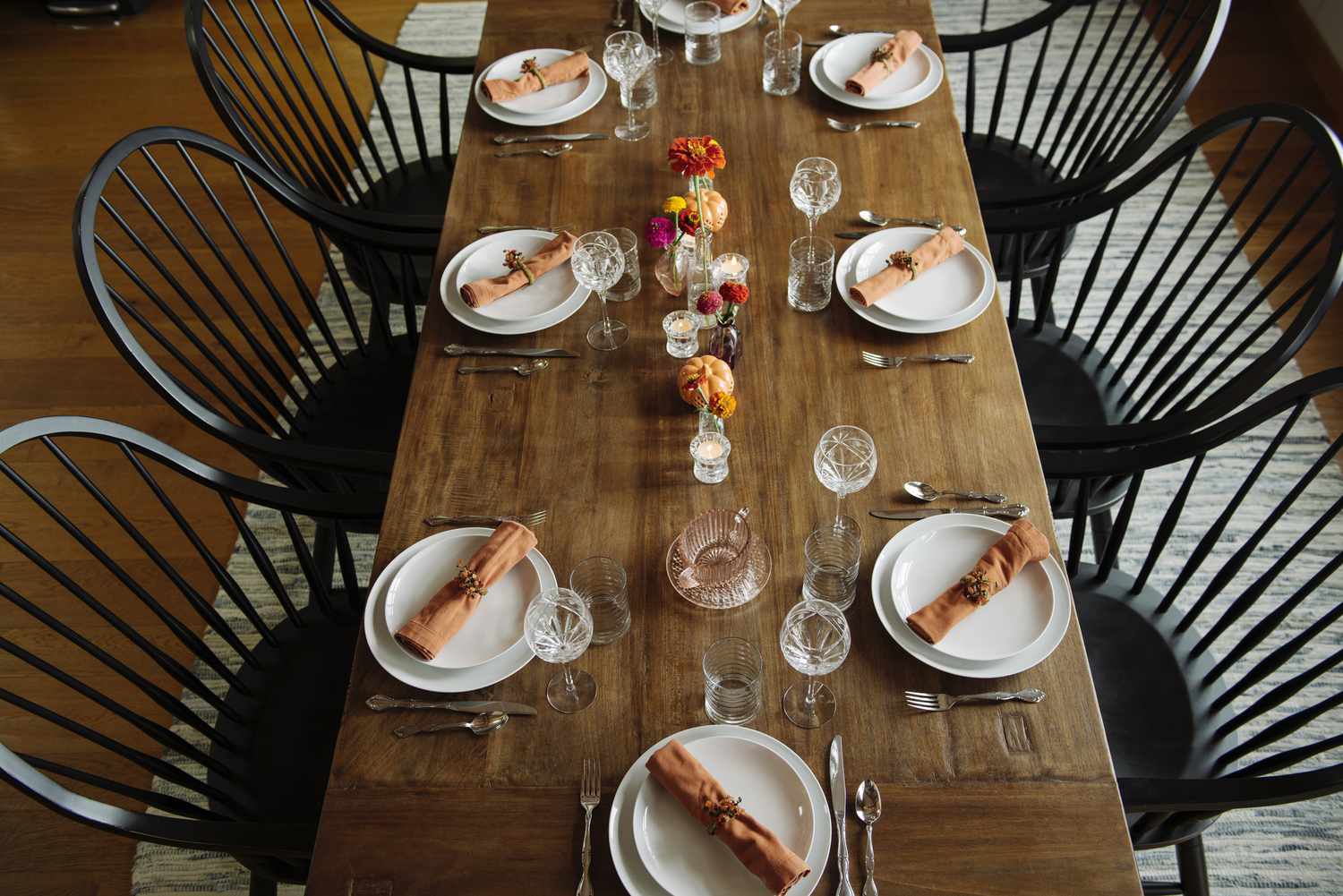 Bordsdukning med orange servetter, blommor och pumpor