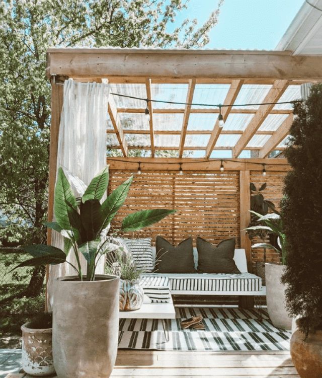 Pergola och träpanel och utomhusdraperi runt däck 