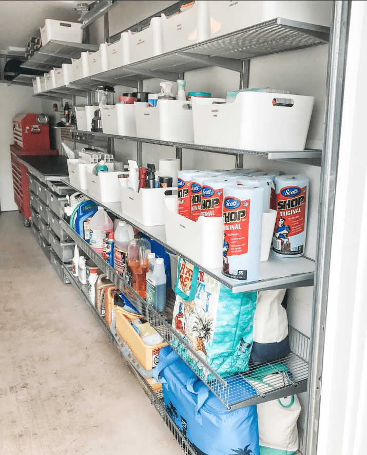 En samling vita lådor fyllda med bulkvaror för hemmet står uppradade i ett garage