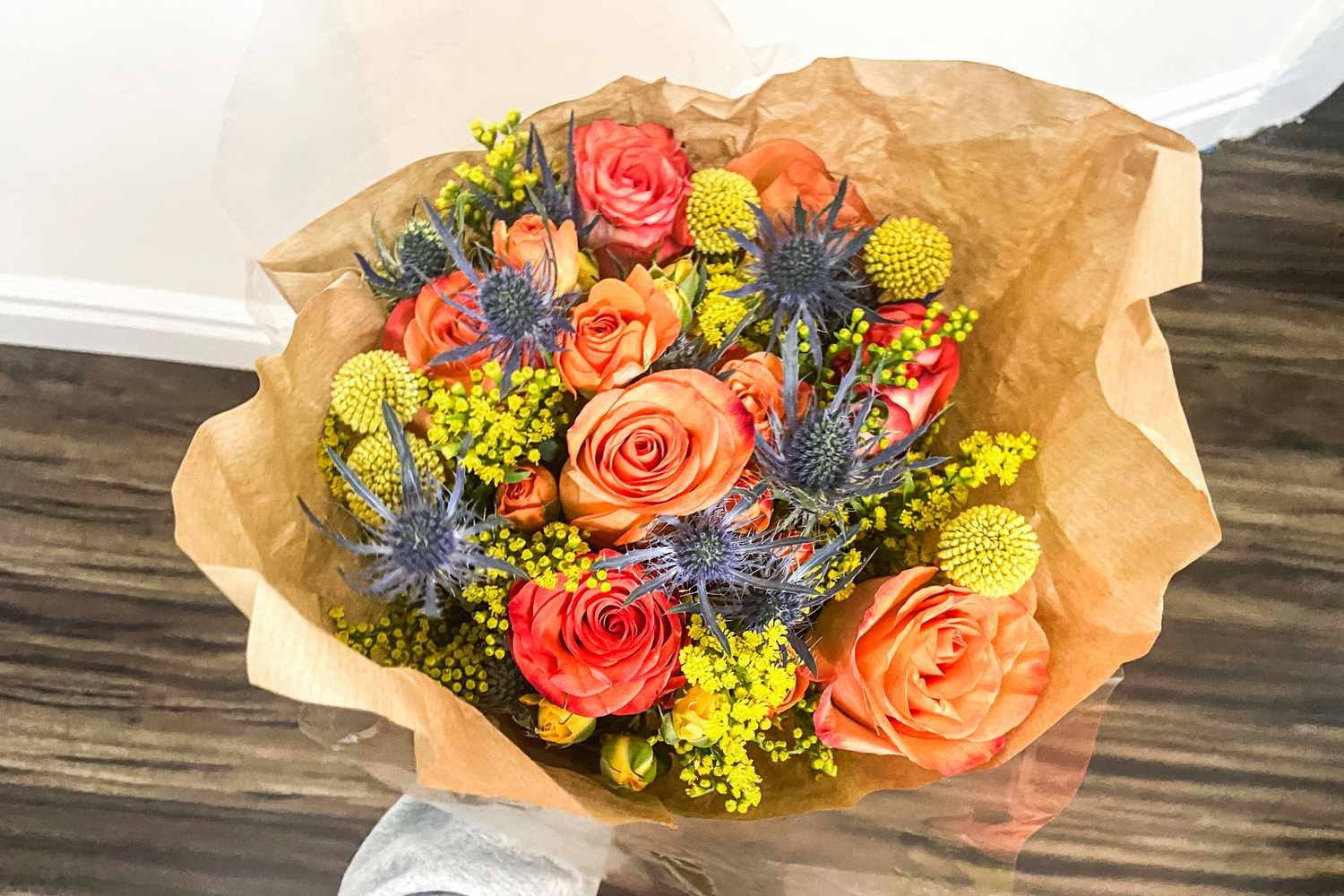 En person som håller en bukett från UrbanStems-tjänsten över ett trägolv