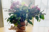 Ett blomsterarrangemang från Farmgirl Flowers framför ett fönster