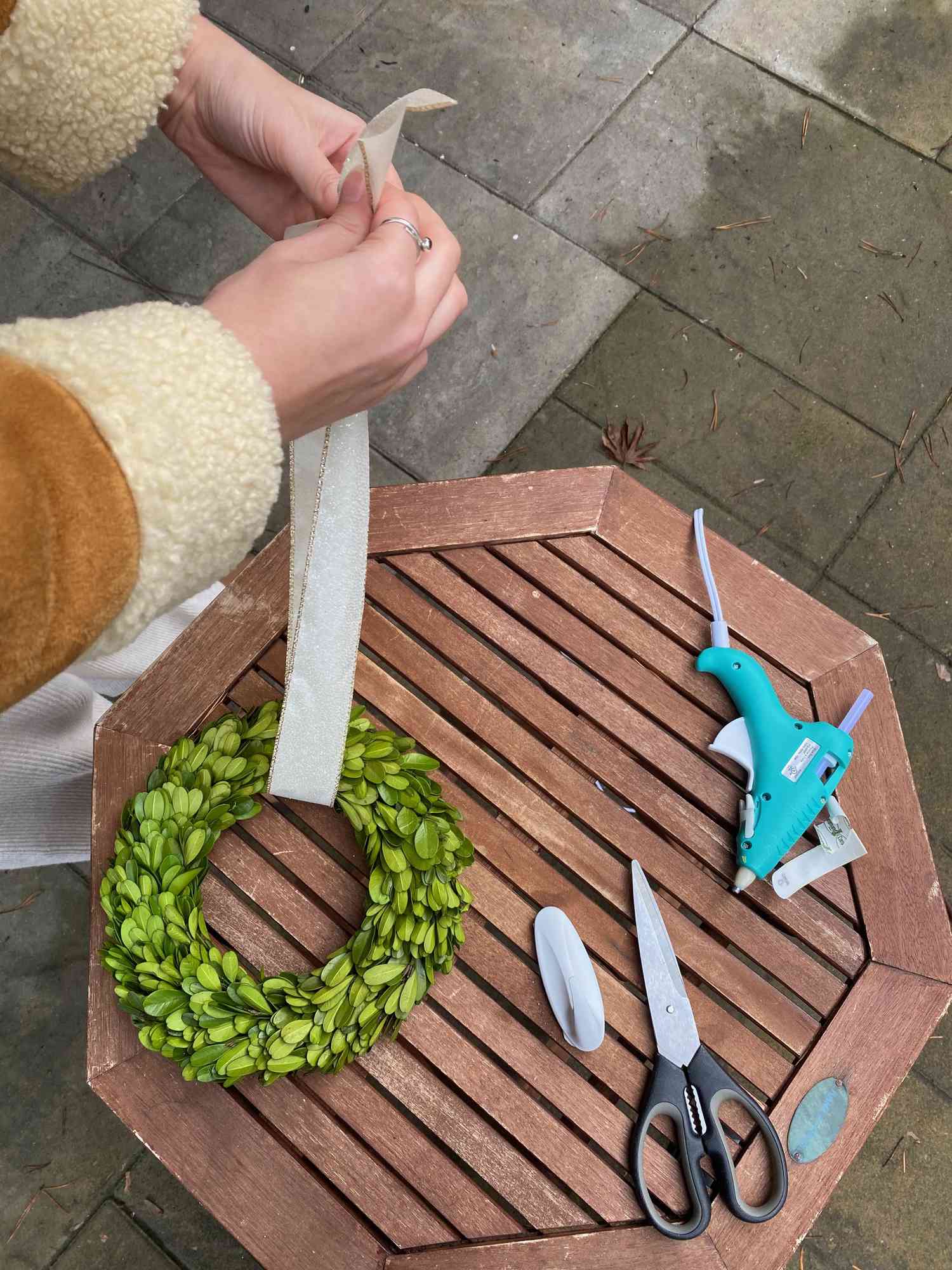 Person som knyter bandet runt kransen