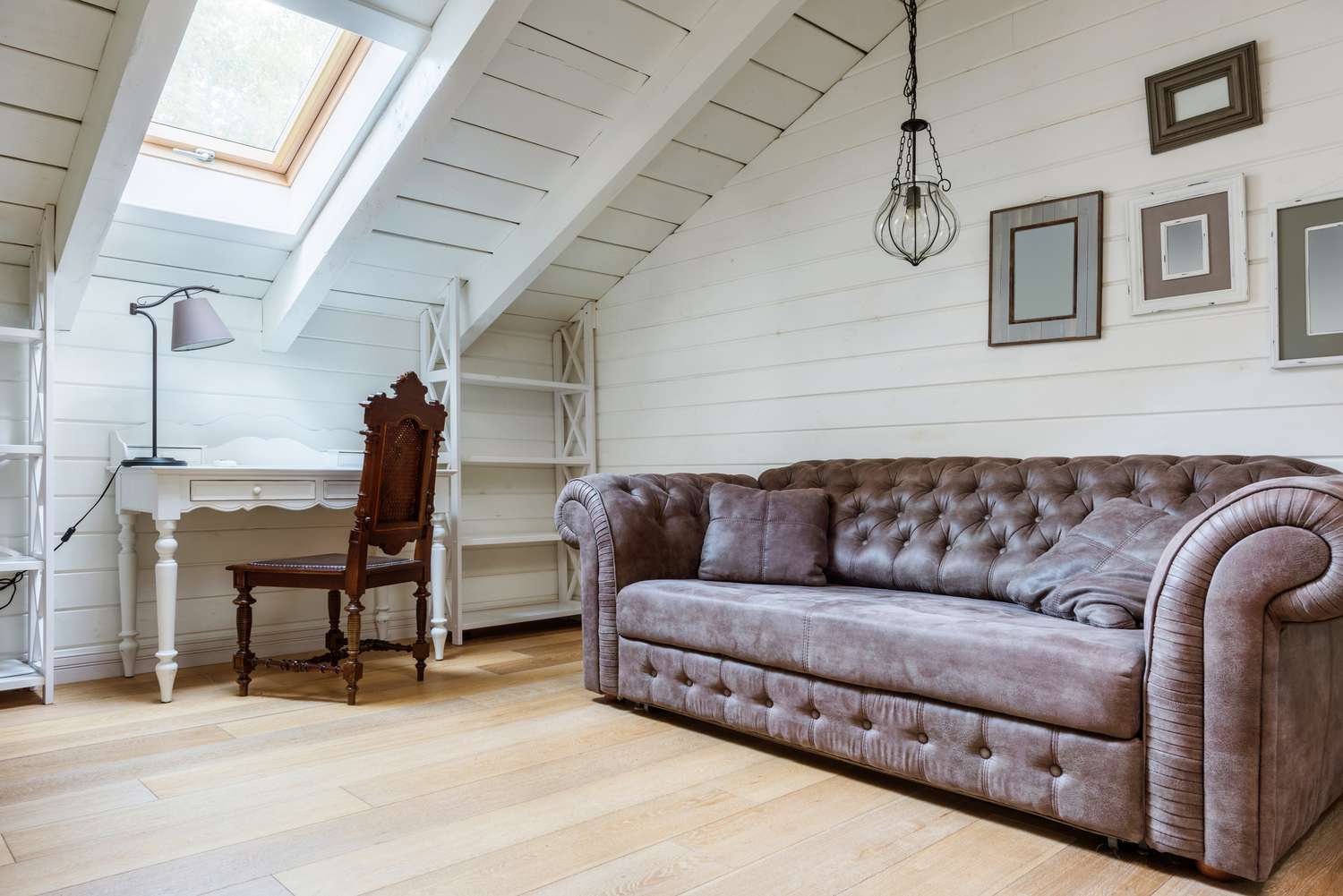 Gray Chesterfield sofa in a white loft room