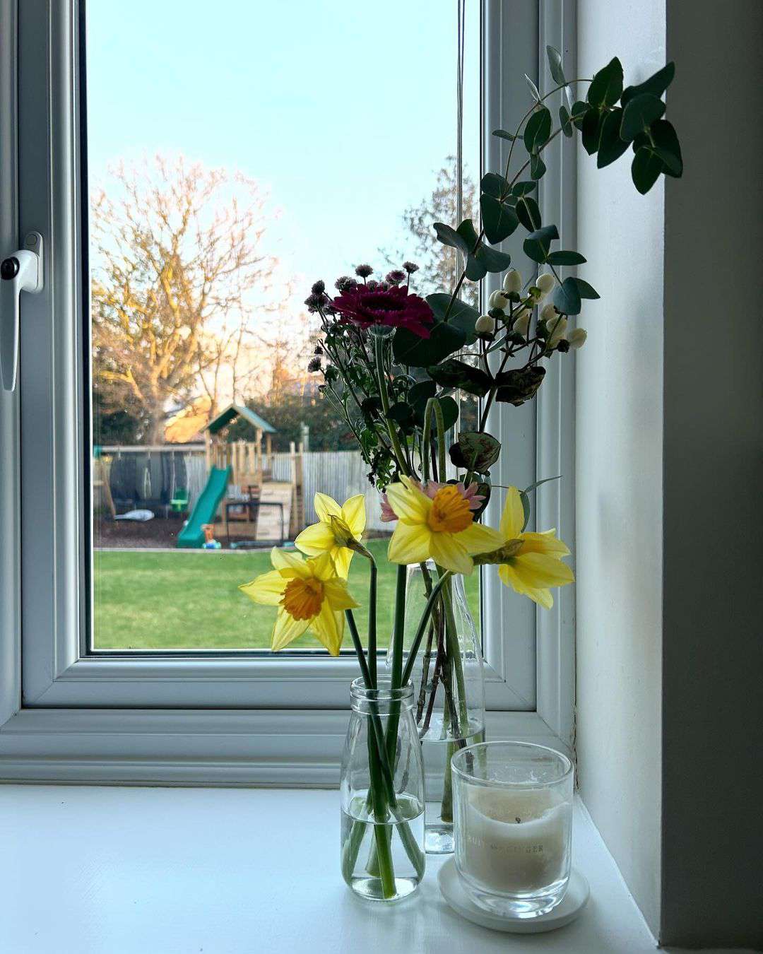 blommor och stearinljus på fönsterbrädan