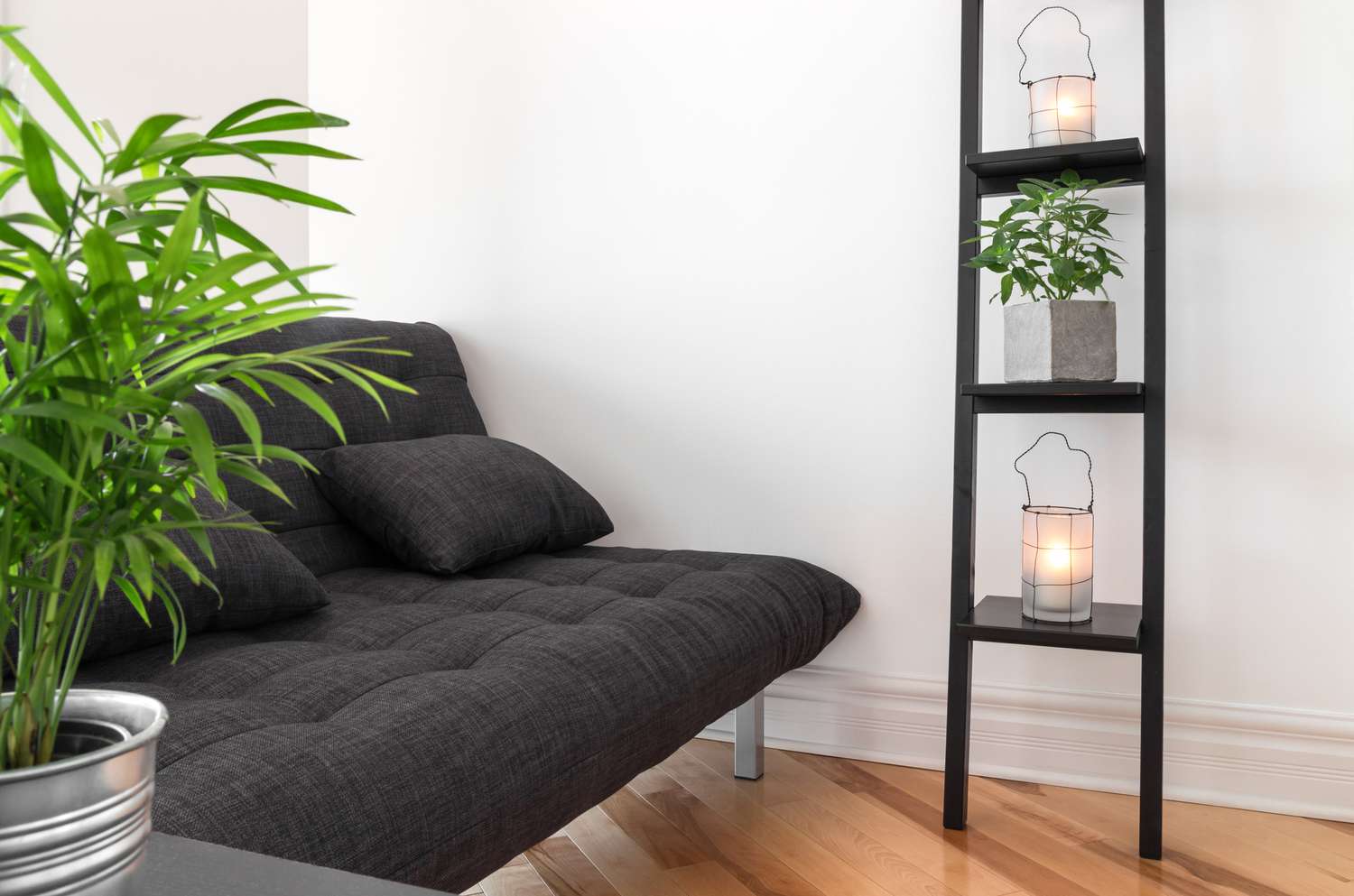 svart futon bredvid bokhylla