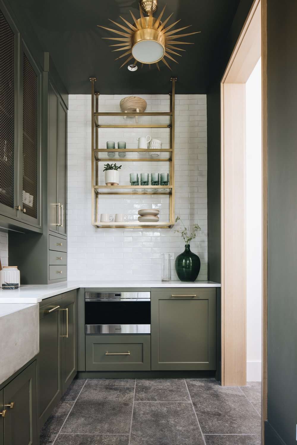 olive green kitchen pantry cabinets with gold-toned hardware