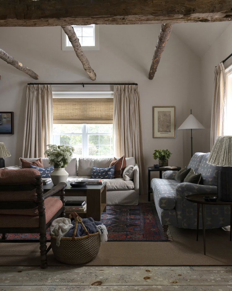 Rustic English living room with wood ceiling beams and cream drapes 