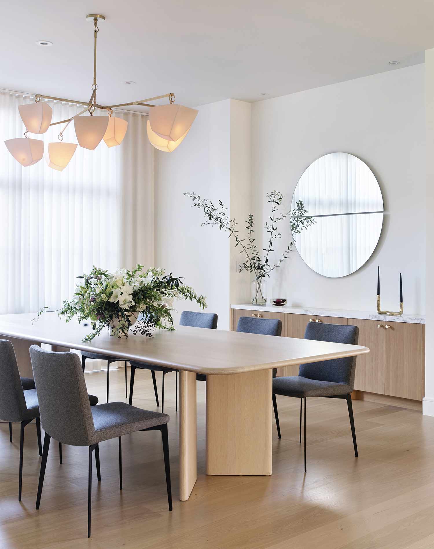 A light and airy neutral dining room with a sculptural chandelier