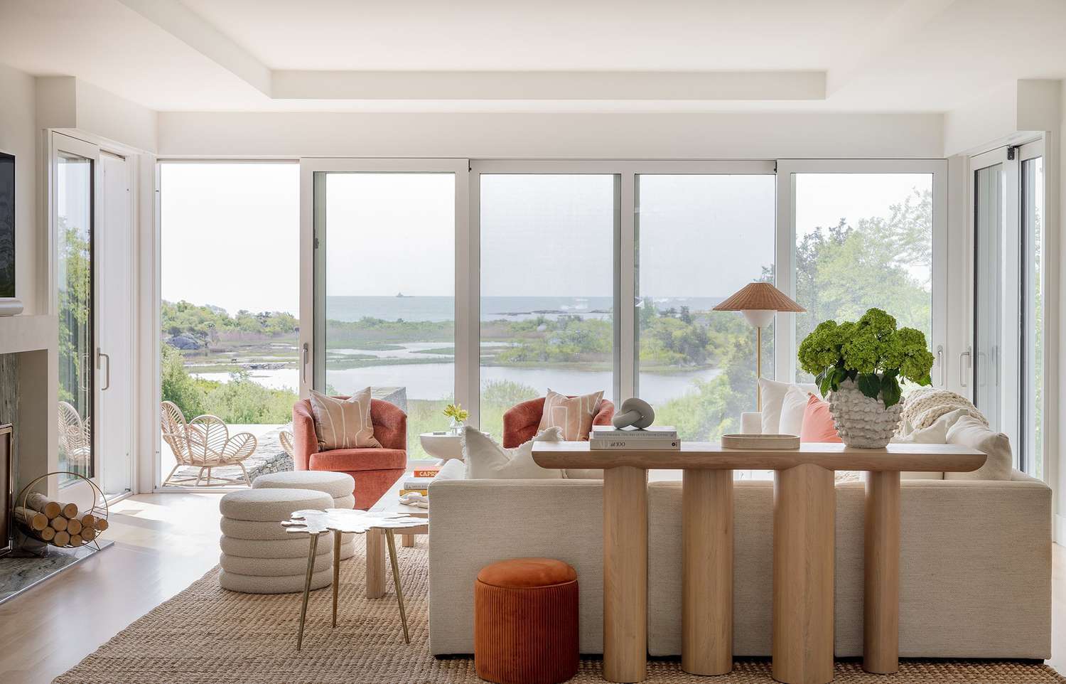 Bright airy coral and white living room with statement console in ash oak finish 