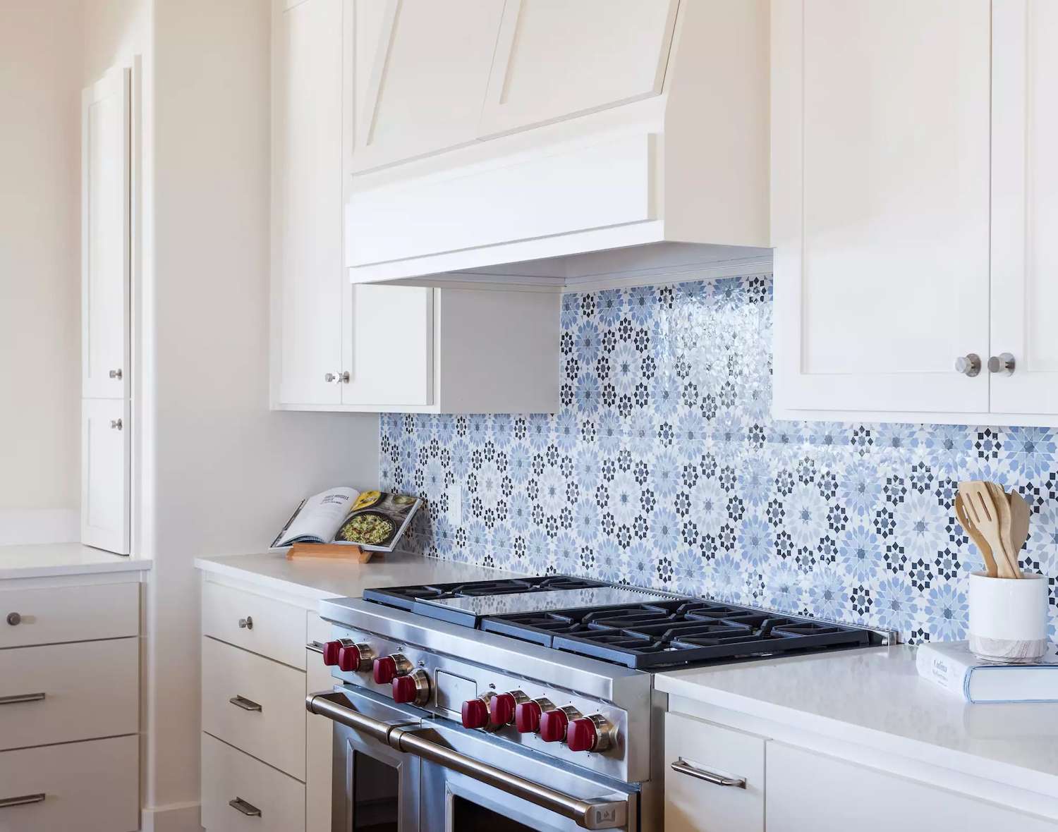 white kitchen cabinets with blue patterned tile backsplash